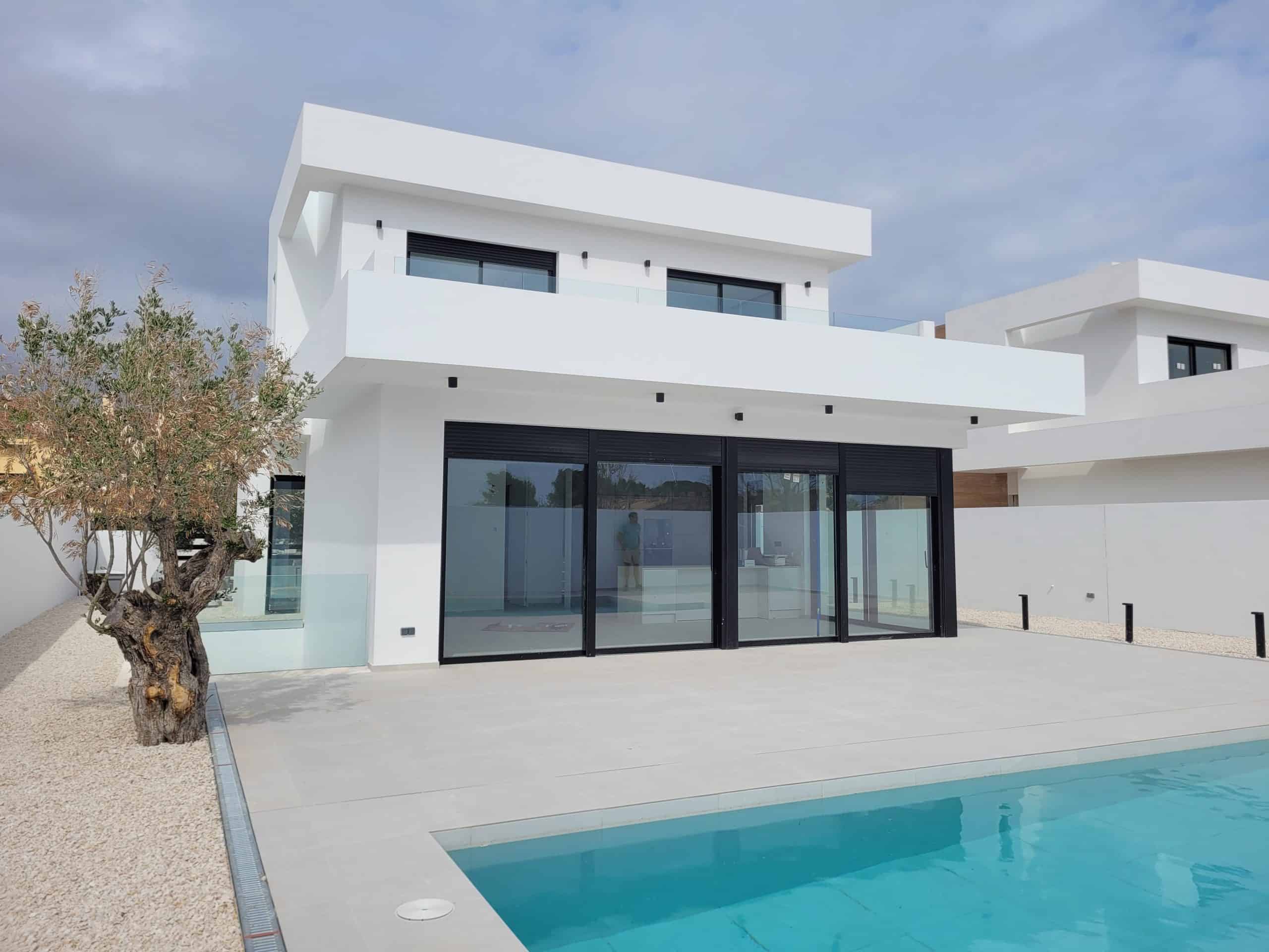 Moderne witte villa met grote glasramen en privézwembad, ideaal voor luxe vakantiehuizen.