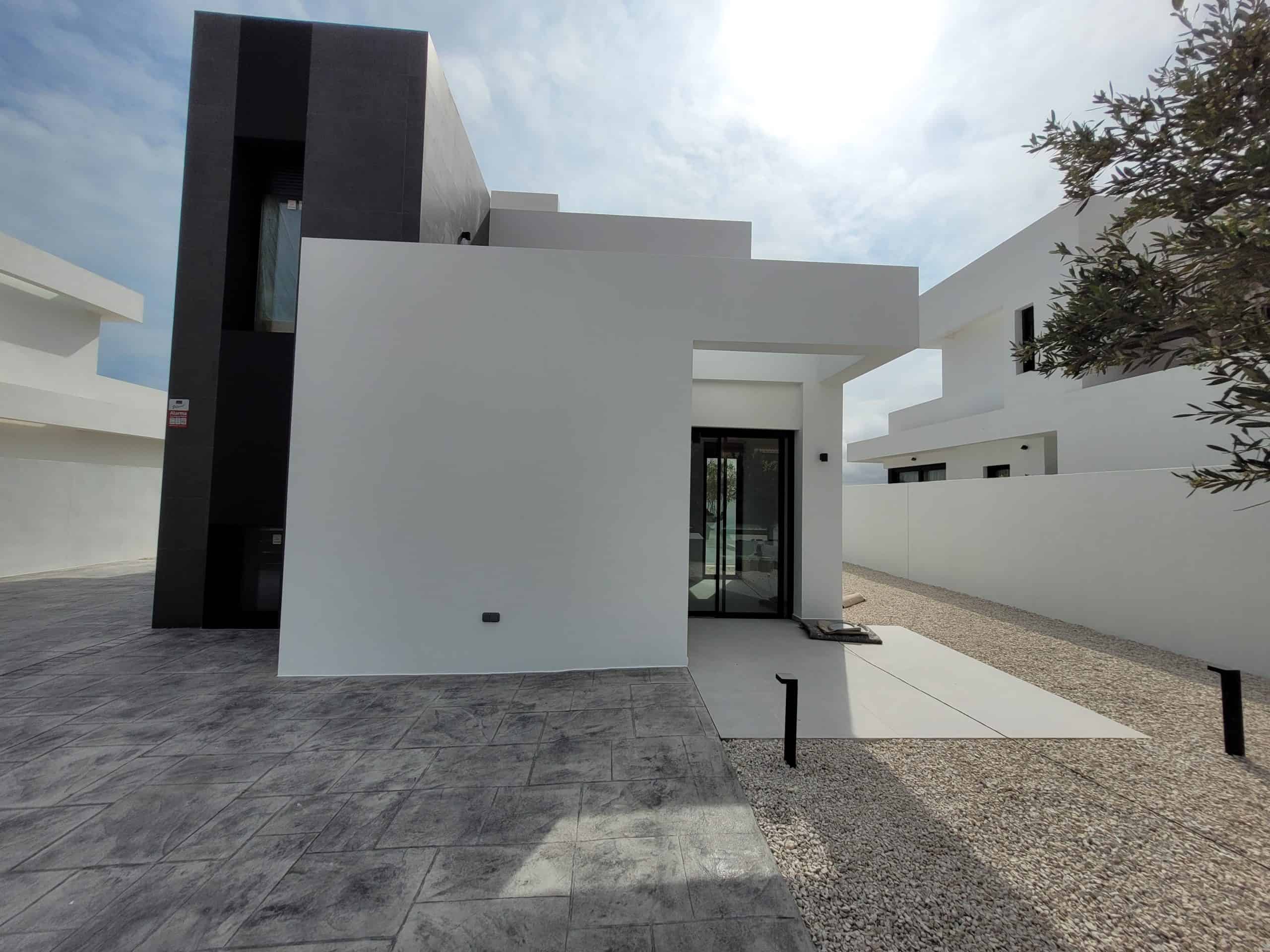 Moderne wit en zwarte minimalistische woning met strakke lijnen en gevelafwerking.