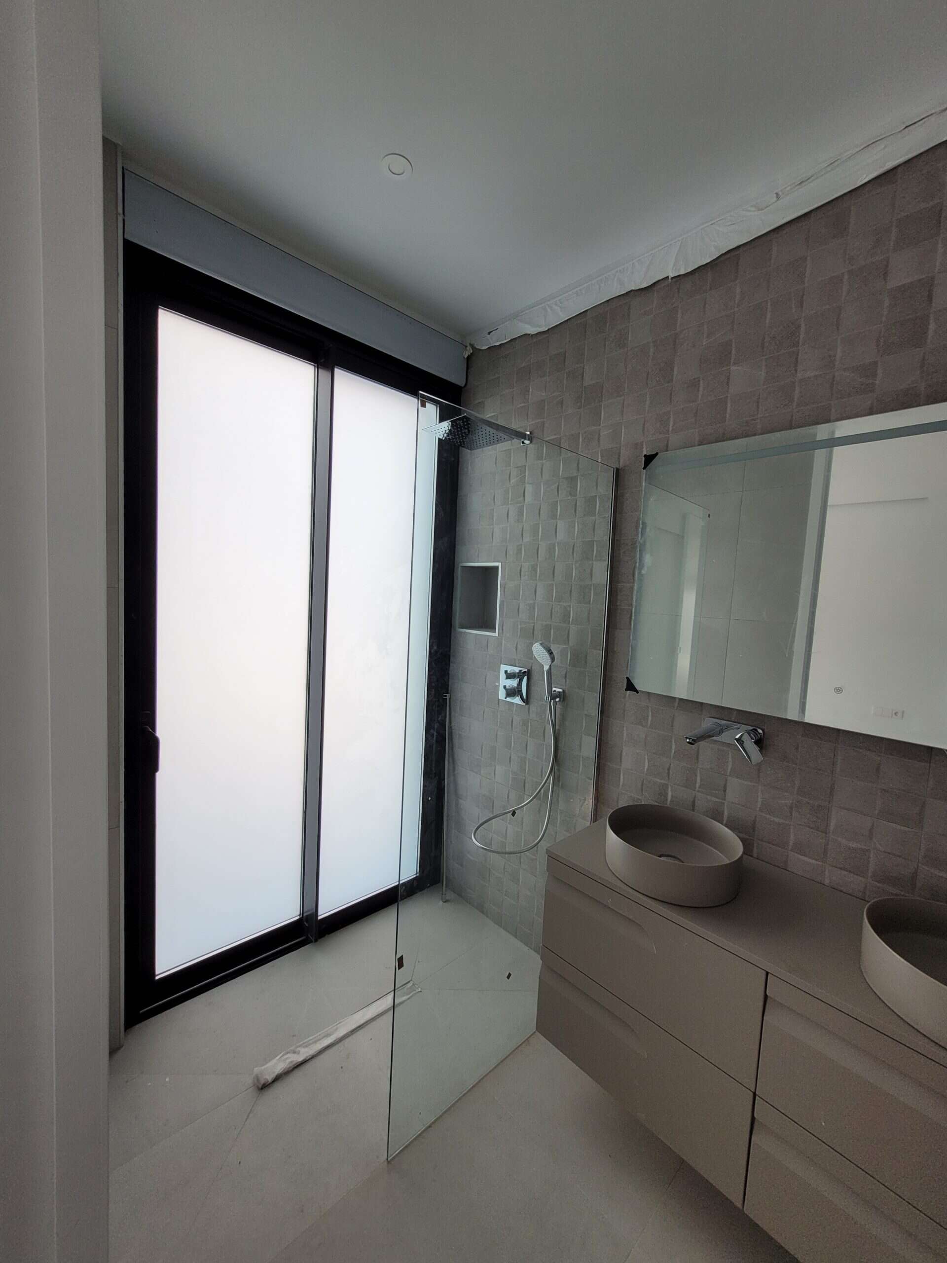 Moderne badkamer met inloopdouche en dubbele wastafel in neutrale tinten, perfect voor een luxe woonruimte.